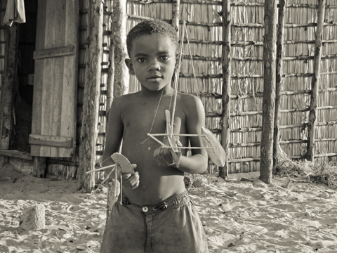 Boy in Madagascar with wooden boats