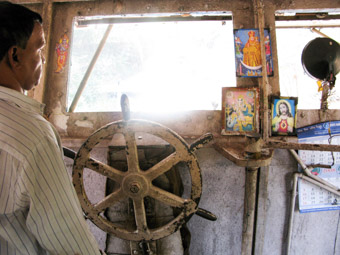 ferry captain with religous icons in goa india 