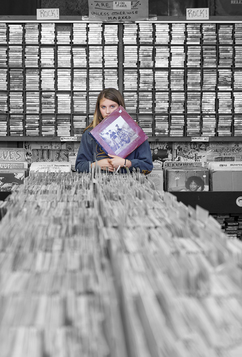 Teenage girl in record shop holding record