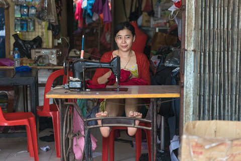 Woman tailor sewing outside her shop Siem Reap Cambodia